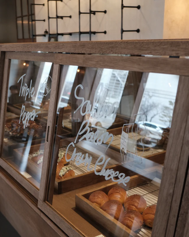 Bread rolls in a wooden bakery display case